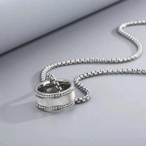 Detailansicht der silbernen Kette mit einem strassbesetzten Muschelring-Anhänger am Band