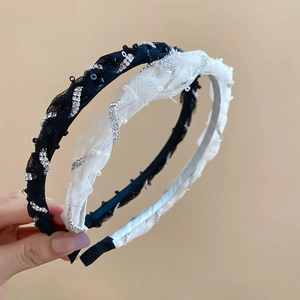 Close-up of twisted mesh headbands featuring sequins, pearls, and rhinestones