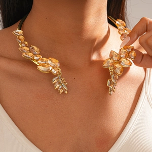 Close-up of statement gold choker featuring amber teardrop crystals and floral leaf design
