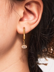 Close-up of 18k gold plated evil eye earrings with white zircon on ear model