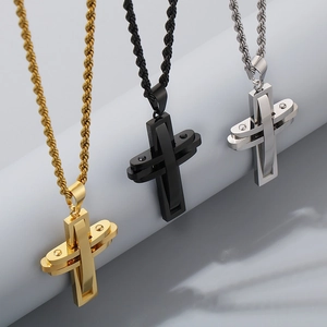 Detailed view of layered cross pendants in gold, black, and silver on twist chains
