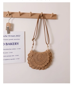 Detail of hand-woven lace pattern on brown crochet shoulder bag with leather strap