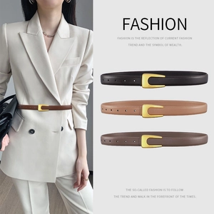 Women's slim leather belt with U-shaped gold buckle in three brown shades on a model