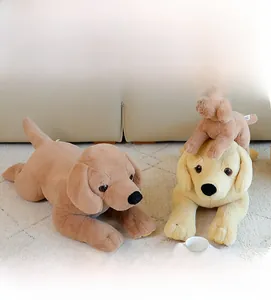Drei Labrador Stofftiere in verschiedenen Größen und Farben auf einem Sofa