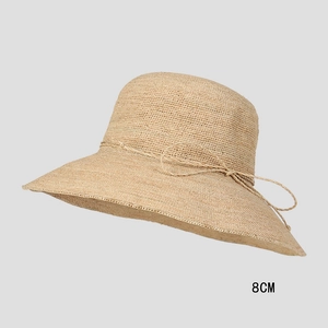 Detail of hand-woven raffia sun hat showing 8cm brim width and decorative ribbon bow