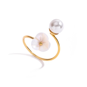 Detail of golden adjustable ring featuring a lustrous pearl and carved shell flower