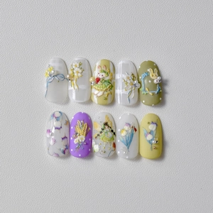 Detail of 3D embossed nail art stickers featuring cartoon rabbits and floral fairy motifs