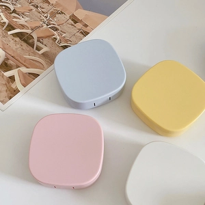 Flat lay of square pastel contact lens cases in blue yellow pink and white matte finish