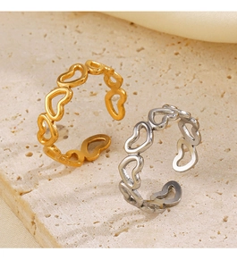 Close-up of gold and silver heart cutout stainless steel rings on a stone base