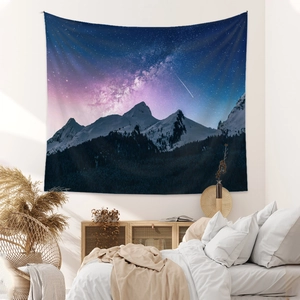 Bohemian starry night sky tapestry with snowy mountains hanging in a cozy bedroom