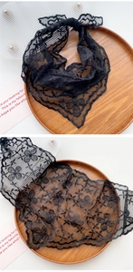 Close-up of black floral lace scarf with butterfly embroidery on wooden tray