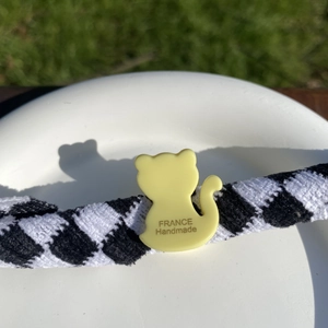 Détail de la pince à cheveux chat en acétate jaune avec inscription France Handmade et ruban