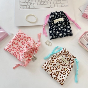 Detailed view of heart and leopard print drawstring pouches with stylish woven labels