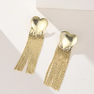 Top view of gold-plated heart tassel earrings with sleek metallic texture on a white surface