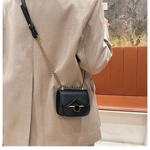Dettaglio della mini borsa a tracolla nera con fibbia dorata e catena per bambini