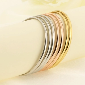 Macro detail of 7-piece minimalist stacking bangle set in gold rose gold and silver