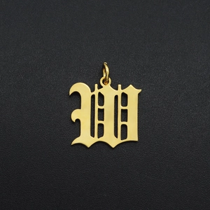 Macro shot of gold-plated stainless steel Gothic letter W pendant for DIY jewelry