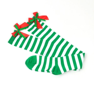 Detail of festive green and white striped over-knee socks with red Christmas bows