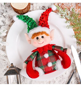 Close-up of a Christmas elf doll in red and green plaid on a festive holiday table