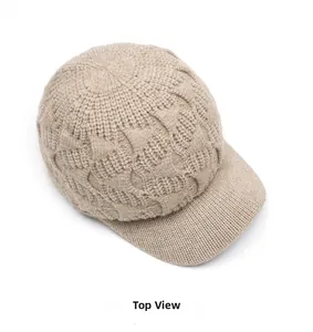 Top view detail of the beige cable-knit baseball cap with thick wool texture
