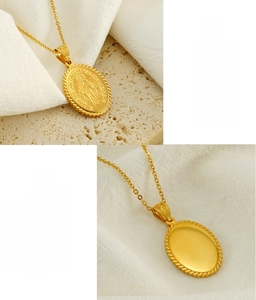 Macro detail of oval gold stainless steel pendant showing Virgin Mary engraving and back mirror finish