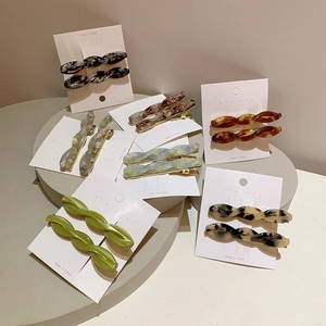 Detail view of twisted acetate hair clips in tortoiseshell and marble patterns on display cards