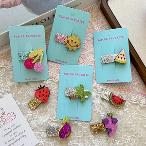 Detail of cute sequined strawberry and cherry hair clips for girls on display card