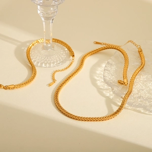 Detail of 18K gold-plated braided chain necklaces with elegant light and shadow