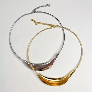 Minimalist gold and silver metal collar necklace with crescent moon pendant and polished finish
