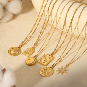 Set of 6 gold plated celestial necklaces with star and moon pendants on elegant fabric