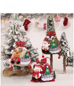Close-up of burlap Christmas gift bags with 3D reindeer, Santa, and snowman plush figures