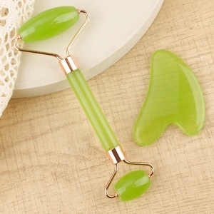 Macro detail of resin jade roller and heart gua sha set on wooden spa background