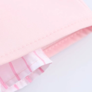 Detail of pink cotton blend fabric featuring striped pattern and precise sewing craftsmanship