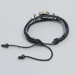 Detail of multi-layer black braided leather bracelet with silver metal beads and pull cord