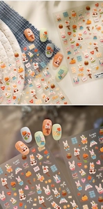 Close-up of 3D embossed rabbit and pumpkin nail art stickers with autumn floral patterns