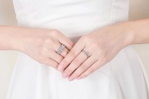 Close-up of a silver six-prong engagement ring and sparkling diamond band set