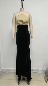 Détail de robe de soirée avec bustier en satin doré et jupe en velours noir à fente