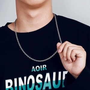 Detail of silver stainless steel cross chain necklace on model with black shirt