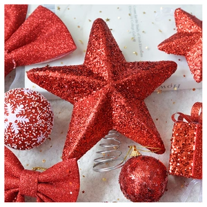 Close-up of red glitter star tree topper and festive ornaments with sequin details