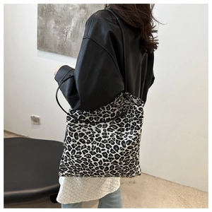 Detailed view of the leopard print canvas shoulder bag worn over a model shoulder