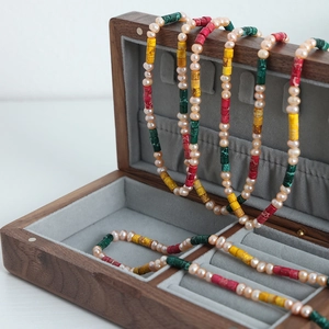 Colorful handmade beaded freshwater pearl necklace displayed in a wooden jewelry box