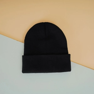 Detailed close-up of the black ribbed knit texture and folded cuff on this winter beanie