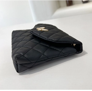 Macro side view of black quilted PU leather crossbody bag with white bow accent