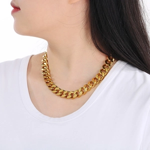 Close-up of 13mm 18K gold-plated chunky Cuban chain necklace on a model wearing a white tee