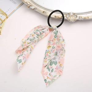 Close-up of floral chiffon ribbon hair scrunchie with pink patterns on a vintage prop