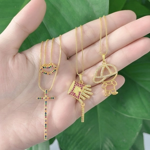 Vue détaillée de quatre pendentifs plaqués or avec zircon coloré sur une paume de main