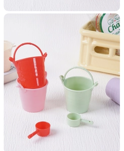 Detalle de cubos y cucharones coloridos en miniatura de plástico para escenas de muñecas