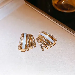 Gold plated C-shaped earrings with shell inlay and zircon accents in multi-layer design