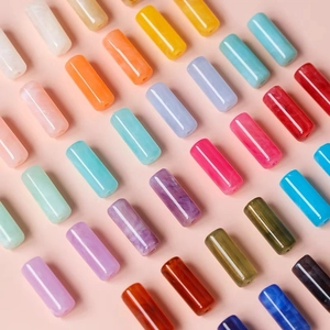 Close-up of colorful acrylic cylinder beads with marble texture for DIY jewelry making