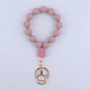 Detailed close-up of pink silicone beaded wristlet keychain with golden metal lobster clasp